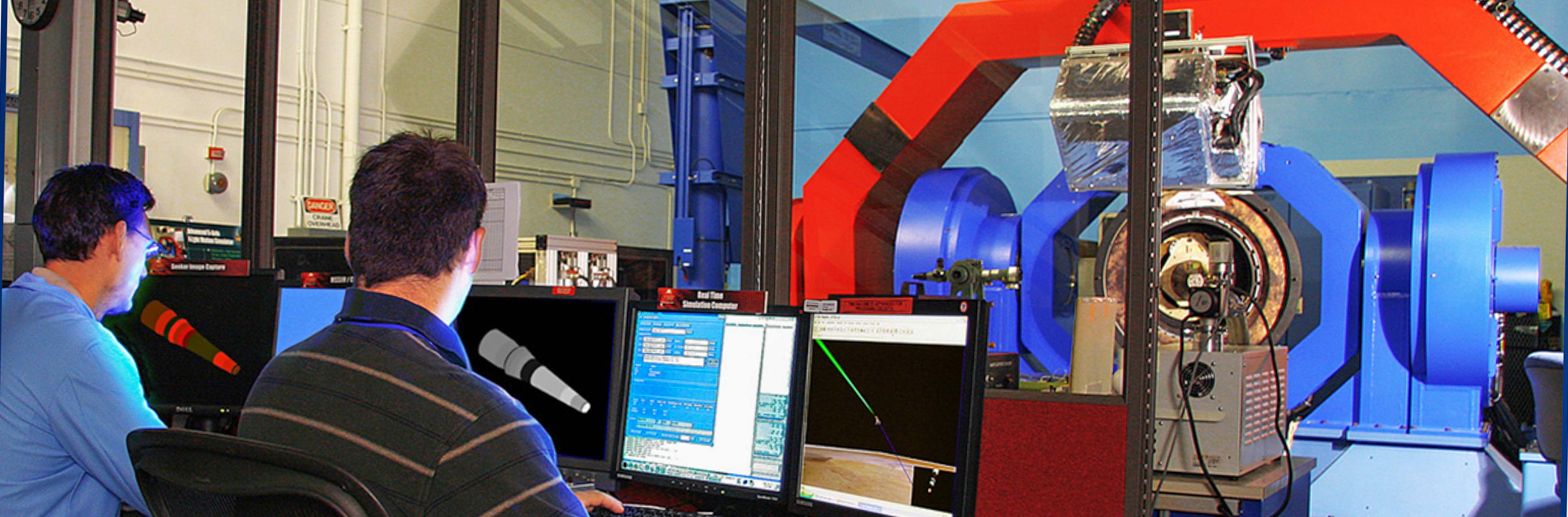 Two researchers in front of large machine