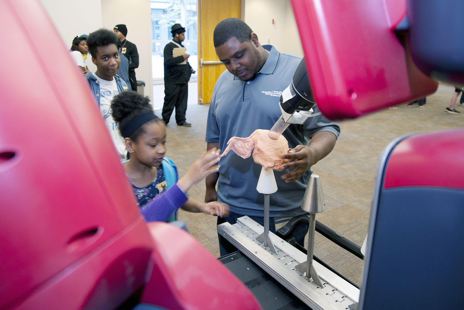 researcher with student using robot