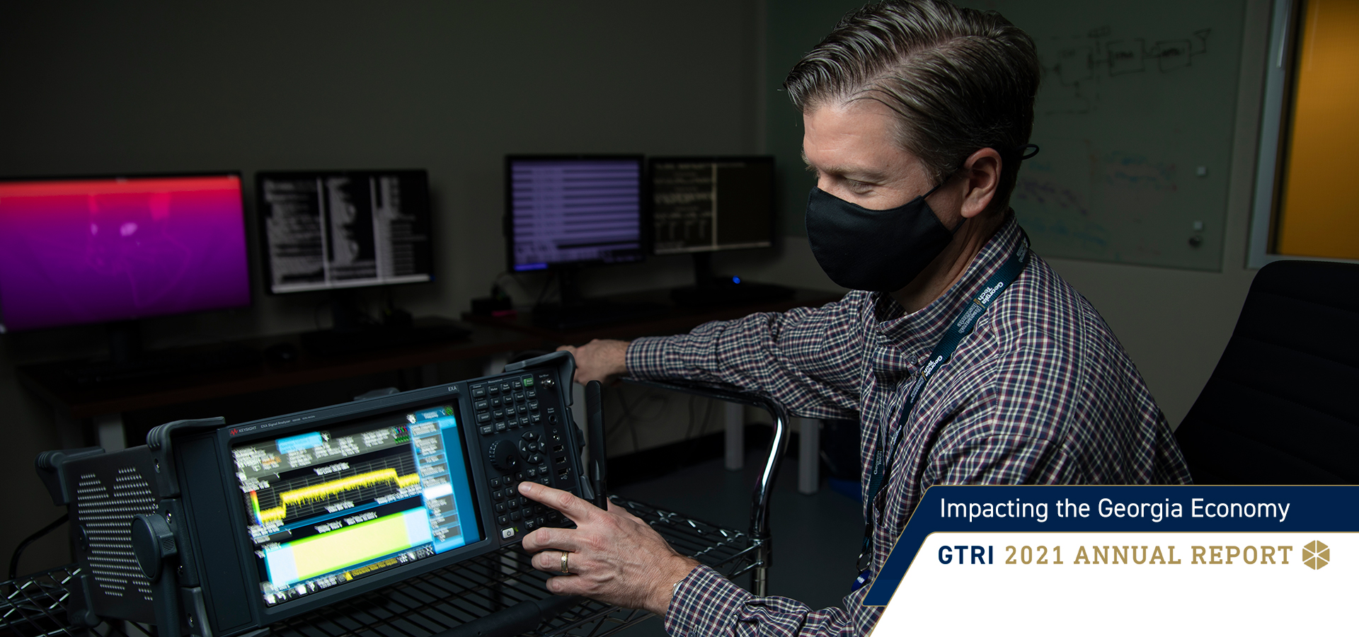 Researcher sitting while making adjustments to electronic equipment 